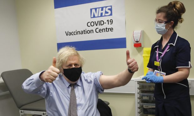 Britain's Prime Minister Boris Johnson gestures after receiving the first dose of AstraZeneca vacci...