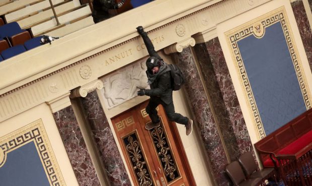 A protester is seen hanging from the balcony in the Senate Chamber on January 06, 2021 in Washingto...