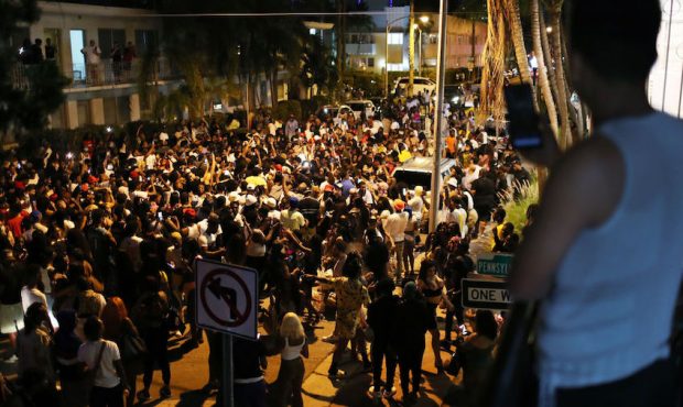 People gather while exiting the area as an 8pm curfew goes into effect on March 21, 2021 in Miami B...