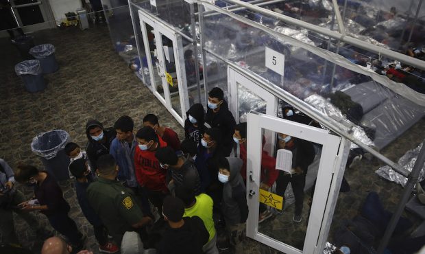 Minors talk to an agent outside a pod at the Department of Homeland Security holding facility run b...