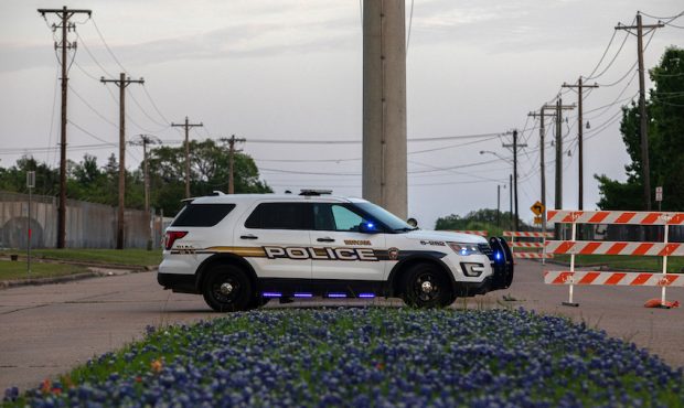 A Bryan Police Department vehicle is parked near the scene of a shooting at Kent Moore Cabinets on ...