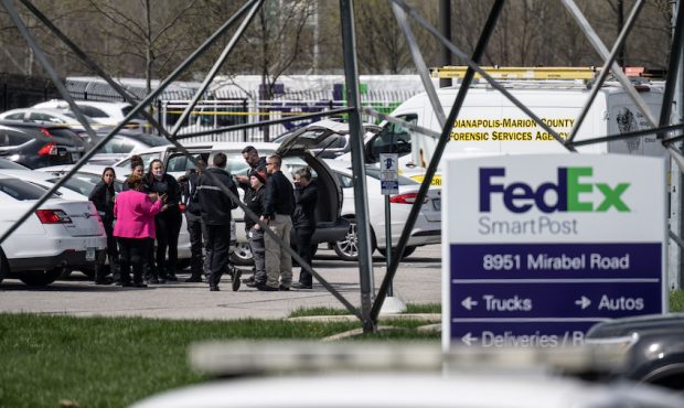 A group of crime scene investigators gather to speak in the parking lot of a FedEx SmartPost on Apr...