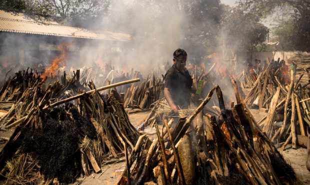A man performs the last rites of his relative who died of the Covid-19 coronavirus disease as other...