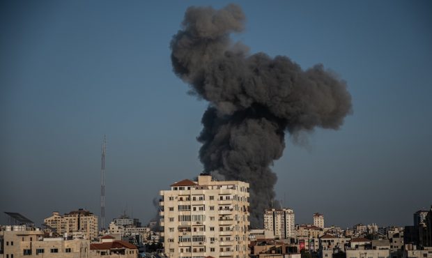 Heavy smoke surround Al-Sharouk tower as it collapses during an Israeli air strike, in Gaza City on...