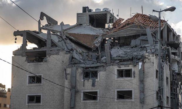 People inspect the rubble of destroyed commercial building and Gaza health care clinic following an...