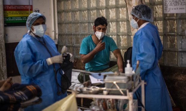 An Indian patient suffering from the coronavirus is treated by medical staff in the emergency ward ...