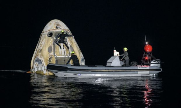 In this NASA handout, Support teams work around the SpaceX Crew Dragon Resilience spacecraft shortl...