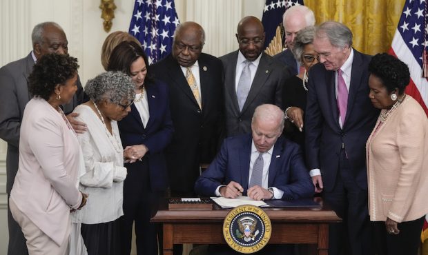 President Joe Biden signs the Juneteenth National Independence Day Act into law in the East Room of...