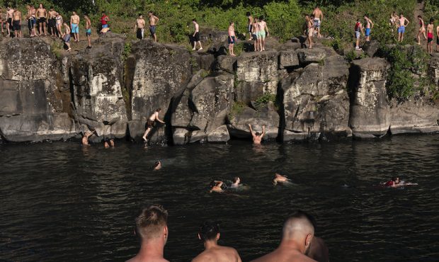 Cliff divers line up along the Clackamas River at High Rocks Park at on June 27, 2021 in Portland, ...