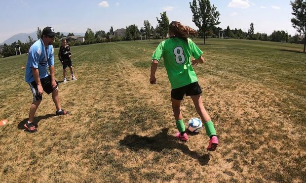 Steve Harris kicks the ball back and forth with his 10-year-old daughter, Sarah Harris. He says coa...