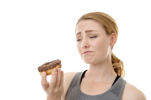 woman contemplates eating a donut