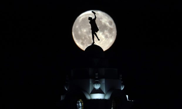 The full buck moon rises over a dancing lady on the Spanish City building in Whitley Bay, England, ...