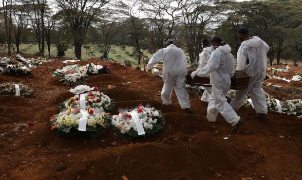 Cemetery workers in protective suits carry the coffin of a COVID-19 victim to be buried at Vila For...