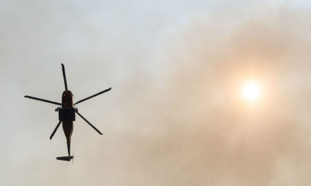 SILVER CREEK, OR - JULY, 23 : A firefighting helicopter flies a mission as the sun shines through s...