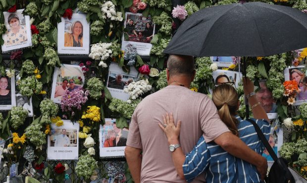 People look at a memorial that has pictures of some of the missing from the partially collapsed 12-...