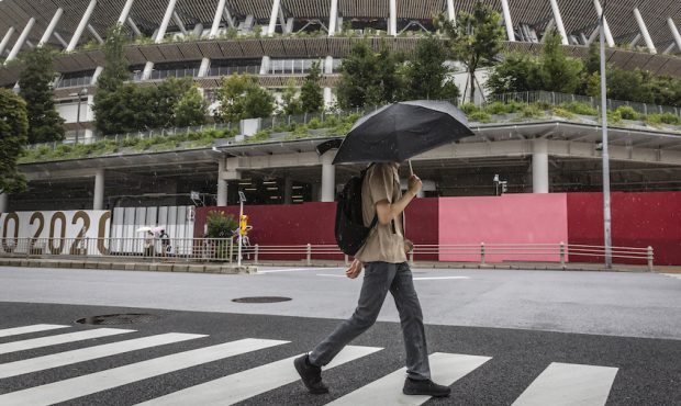 A man walks past Olympics Stadium on July 27, 2021, in Tokyo, Japan. Tropical Storm Nepartak is due...