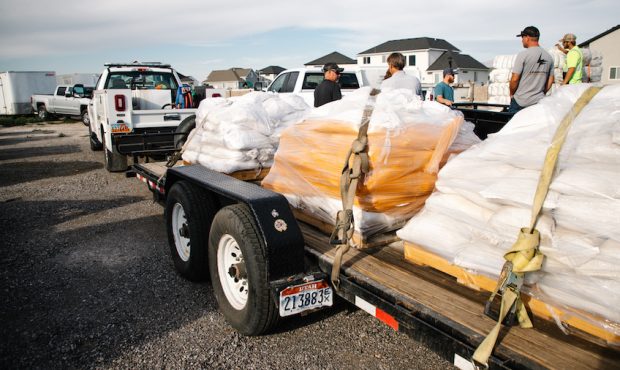 Employees from Lehi City, Draper City and Vineyard City prepare donated sandbags for travel to Ceda...