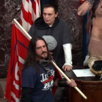 Paul Allard Hodgkins, who breached the U.S. Senate chamber carrying a Trump campaign flag, was sentenced Monday to eight months behind bars, the first resolution for a felony case in the Capitol insurrection. (Department of Justice)