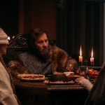 The Lord (Joel Edgerton) sits for a meal in A24 Films' THE GREEN KNIGHT
