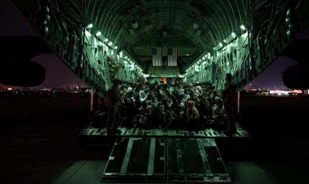 A U.S. Air Force aircrew, assigned to the 816th Expeditionary Airlift Squadron, assists evacuees ab...