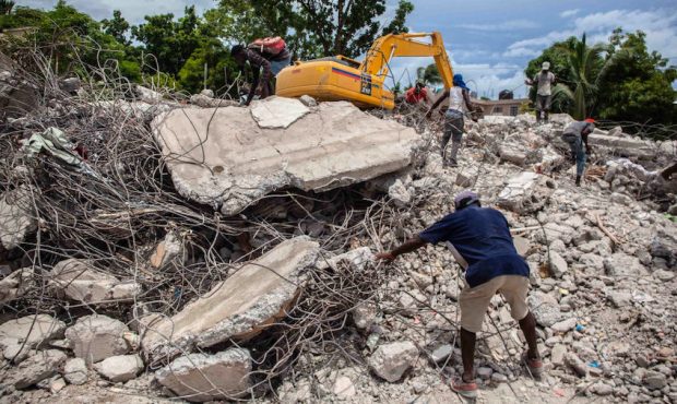 Haitians search for valuable metals among the debris of a collapsed building after a 7.2-magnitude ...