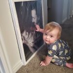 One-year-old Greyson Mair touches a photo of his late father, Jordan Mair, holding him as  a newborn. Just two months after Greyson was born, Jordan died by suicide. (Summer Smart)