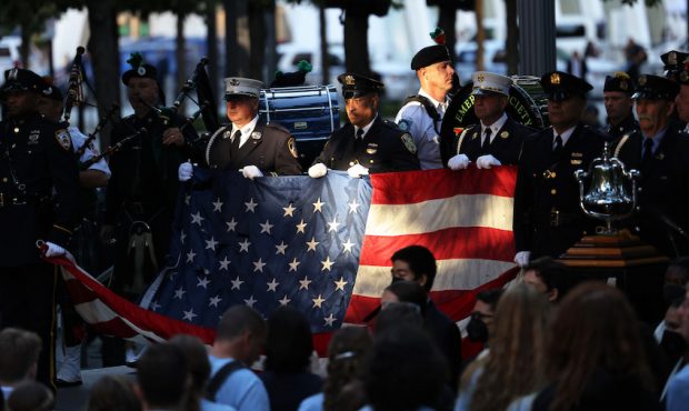 Members of NYPD, POPD, and FDNY hold a U.S. flag during the singing of the National Anthem at the a...