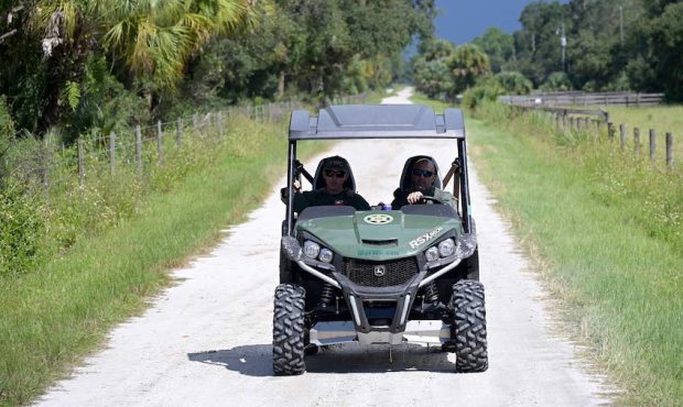 Florida Fish and Wildlife Commission officers ride up a private road near the entrance of the Carlt...