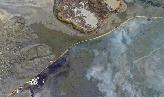 In an aerial view, a containment boom blocks oil-contaminated water (L) in the area of the Talbert ...
