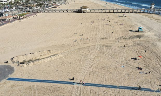 In an aerial view, few people gather along the beach about one week after an oil spill from an offs...