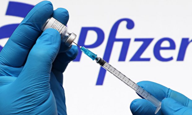 In this photo illustration, a medical syringe and vials of the Pfizer US pharmaceutical corporation...