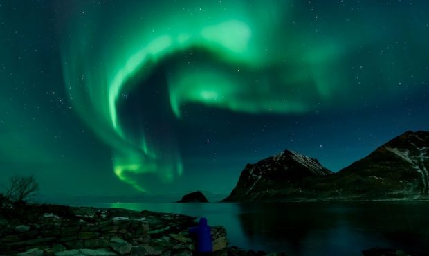 A person watches Northern Lights on March 9, 2018, in Utakleiv, northern Norway, Lofoten islands, w...