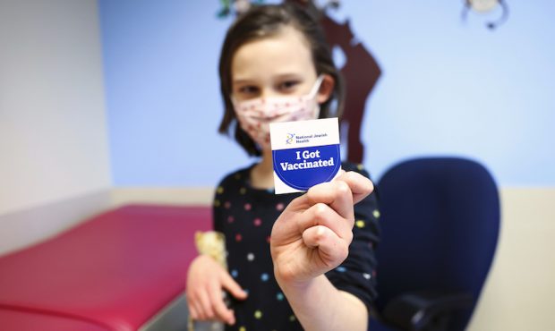 Margaret Sponsler, 7, holds out a sticker after receiving a dose of the pediatric COVID vaccine at ...