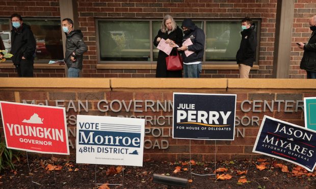 With a cold rain falling, voters stand in line to cast their ballots at the McClean Government Cent...