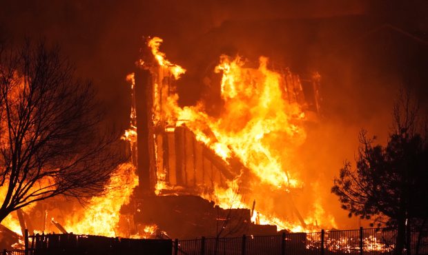 Homes burn as a wildfire rips through a development near Rock Creek Village, Thursday, Dec. 30, 202...