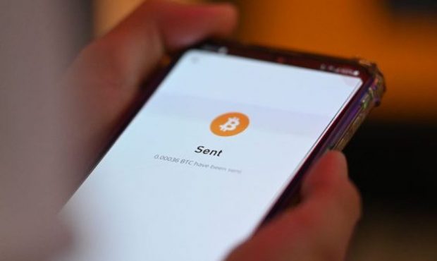 A person uses a cell phone to pay with Bitcoins during the Latin Bitcoin conference (LABITCONF) in ...