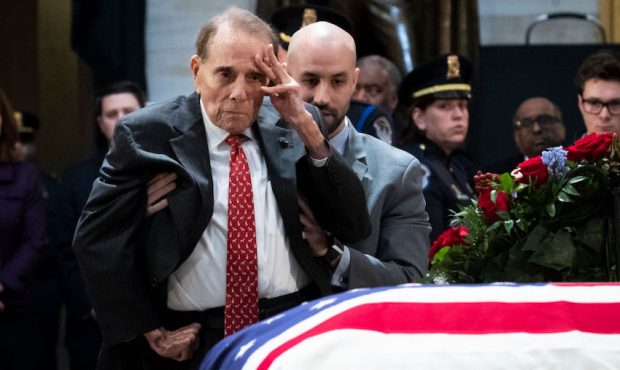 Former Senator Bob Dole stands up and salutes the casket of the late former President George H.W. B...