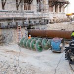 Large pipes are inserted under the existing footings of the building (a process called jack and bore) and the dirt within the pipes is drilled out with a machine using the large green augers during the Temple Square renovation project, Salt Lake City, December 2021. (The Church of Jesus Christ of Latter-day Saints)