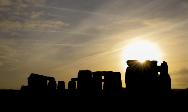 AMESBURY, ENGLAND - DECEMBER 22:  The sun rises over Stonehenge,  as people take part in a winter s...
