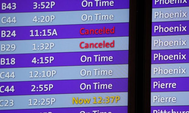 Cancelled flights are noted in red on an electronic arrival board in the terminal of Denver Interna...