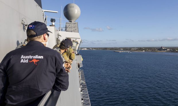 In this photo provided by the Australian Defence Force, crew on board HMAS Adelaide watch as the sh...