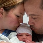 The Englands kiss their newborn daughter, Piper. (Intermountain Healthcare)