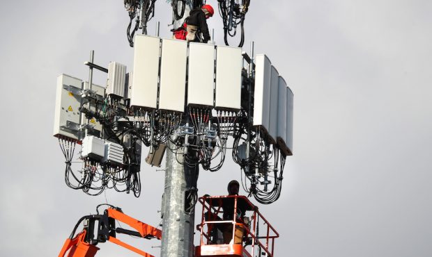 FILE: Workers rebuild a cellular tower with 5G equipment for the Verizon network on Nov. 26, 2019, ...