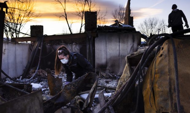 Allison Price, left, and her boyfriend, Leonid Grachev, right, dig through the rubble at his parent...