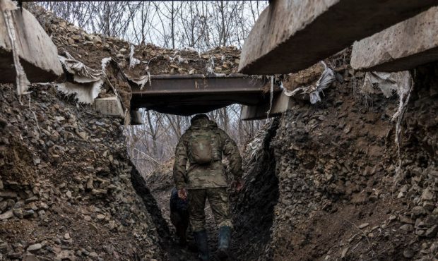 A Ukrainian soldier, who goes by the nickname Chorny, walks in a trench on the front line on Decemb...
