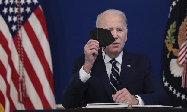 President Joe Biden holds a mask as he gives remarks on his administration's response to the surge ...