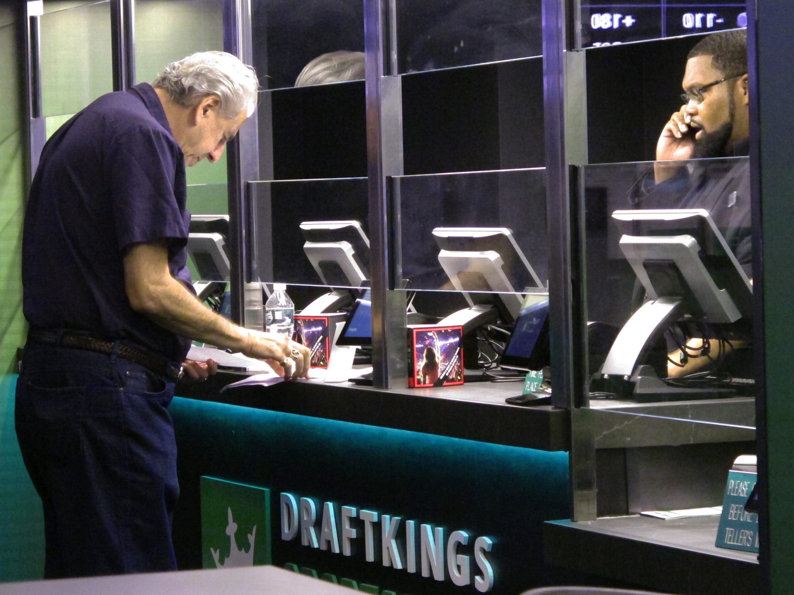 In this Oct. 8, 2019 photo, a customer makes a sports bet at the DraftKings sports book at Resorts ...