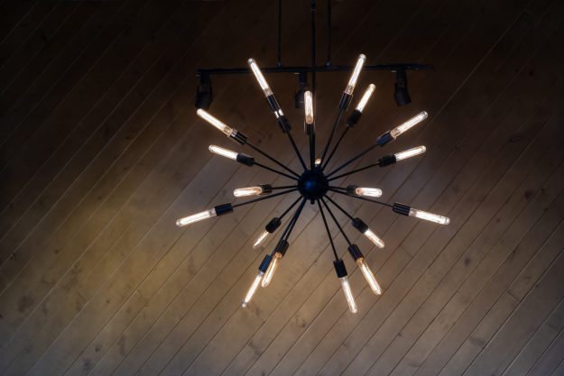 chandelier with modern contemporary design and long lightbulbs coming out of a black sphere