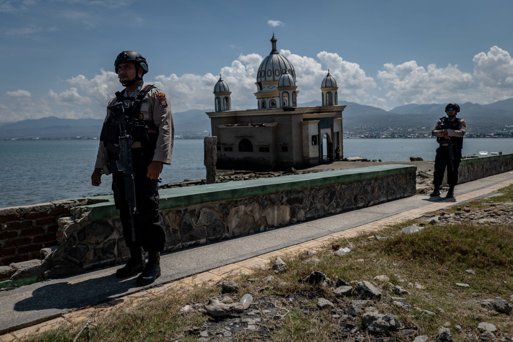 FILE: PALU, INDONESIA - SEPTEMBER 28: Indonesian police stand guard as people take a part of mass p...