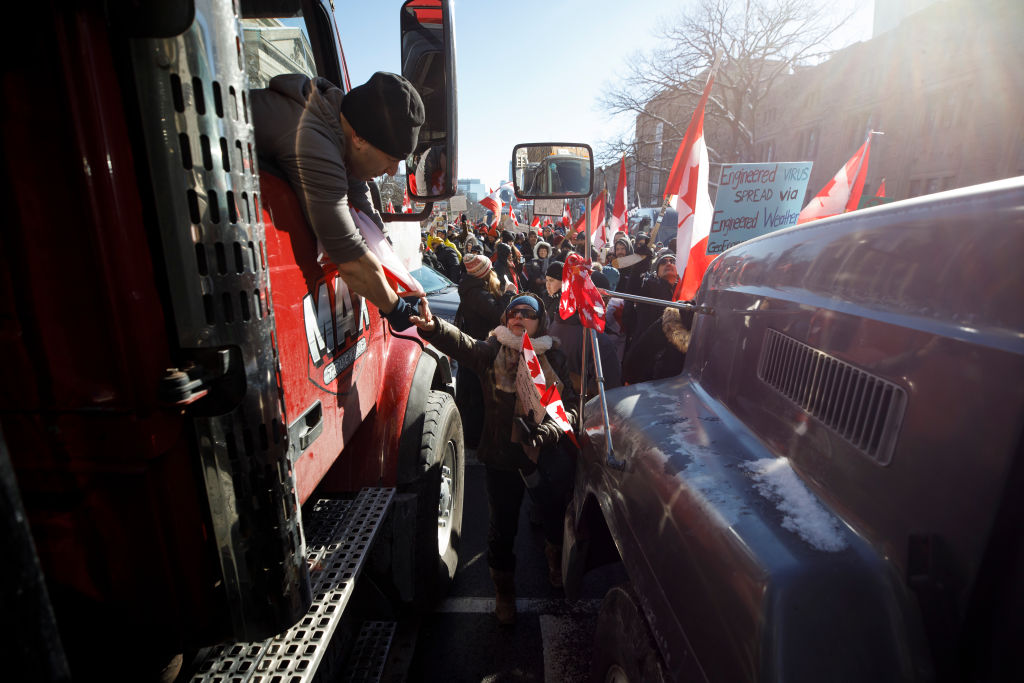TORONTO, ON - FEBRUARY 05: A supporter shakes the hand of a trucker as a convoy of truckers arrives...